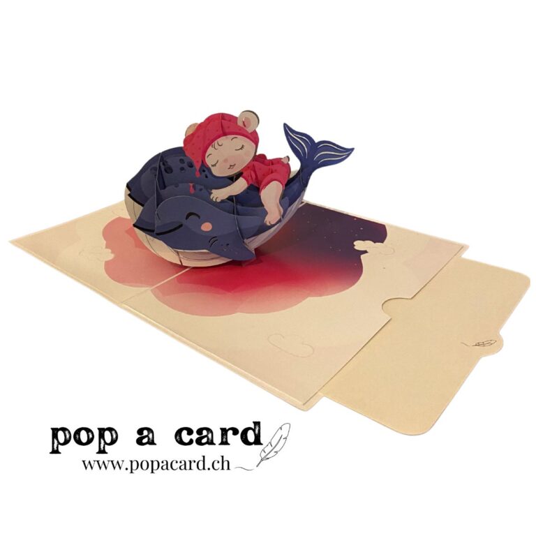 Open 3‑D card shows sleeping baby atop navy whale under starry sky