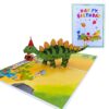 Open 3D pop-up birthday card with a stegosaurus in a party hat and little dinosaurs, next to its front cover