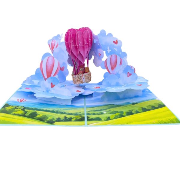 Front view of the open 3D pop-up love card with a pink heart-shaped hot air balloon above clouds